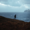 silhouette of person on cliff near sea